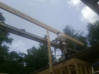 Carpenter setting a ridge beam over a new addition frame — Ice Dam Removal by Roofing Brothers in West Farmington
