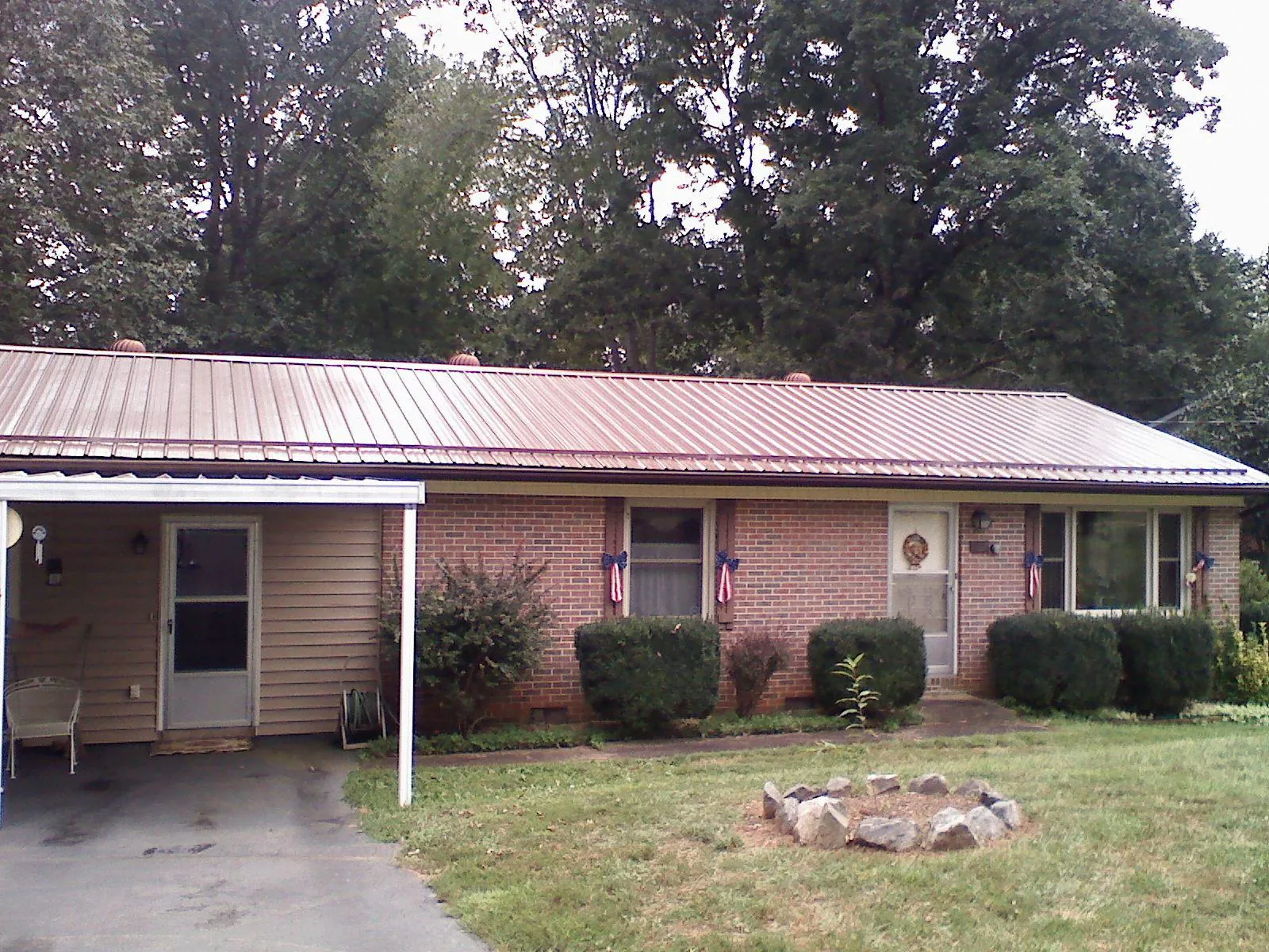 Bronze metal roof and carport on a brick ranch home — Roof Repair work by our crew in West Farmington